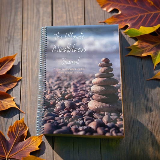 Ultimate mindfulness journal, seen from above lying on a wooden table with scattered autumnal leaves around it