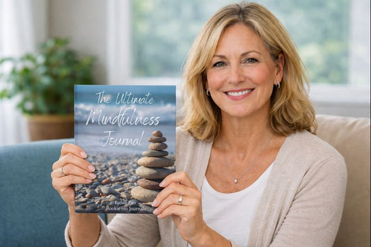 Woman holding a book titled 'The Ultimate Mindfulness Journal' with a blurred background
