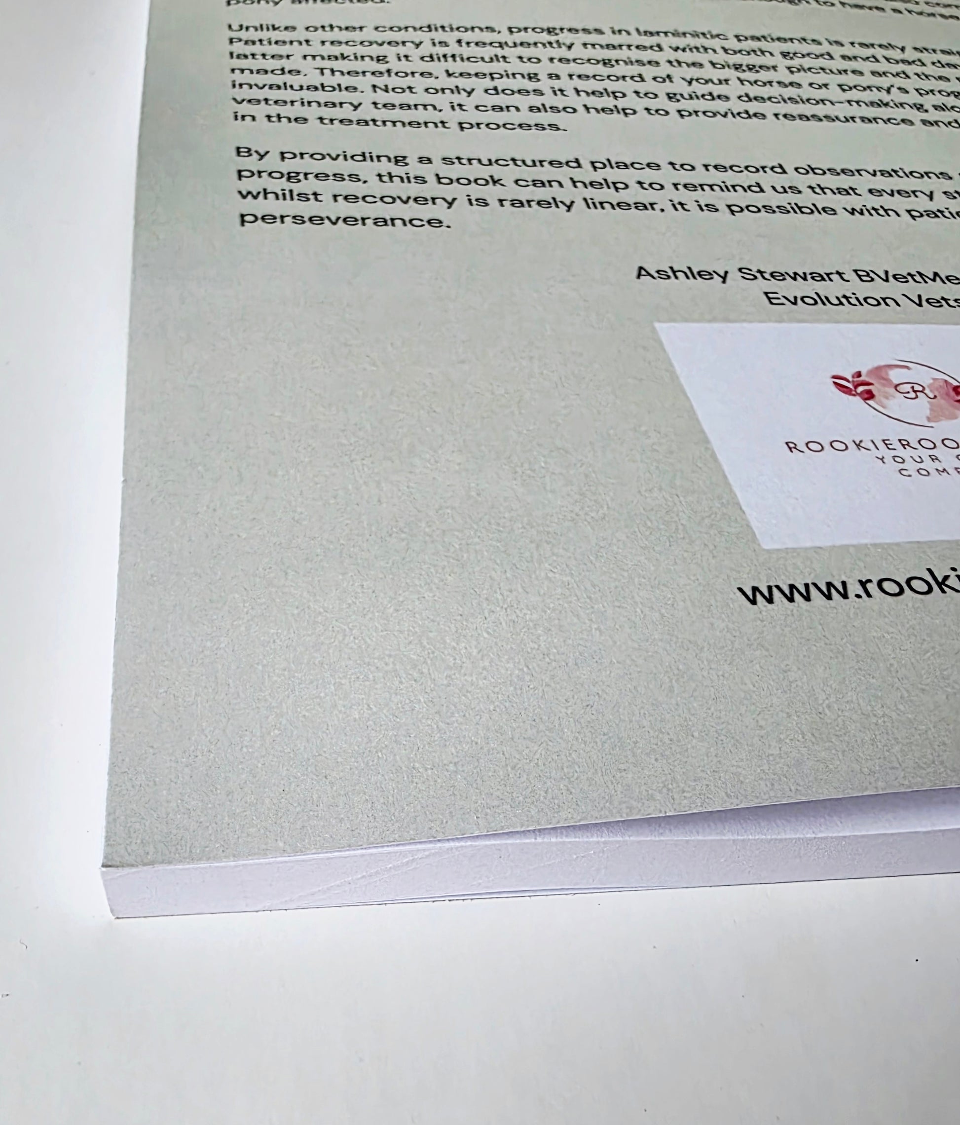 Green back cover of a journal with text and a logo on a white background