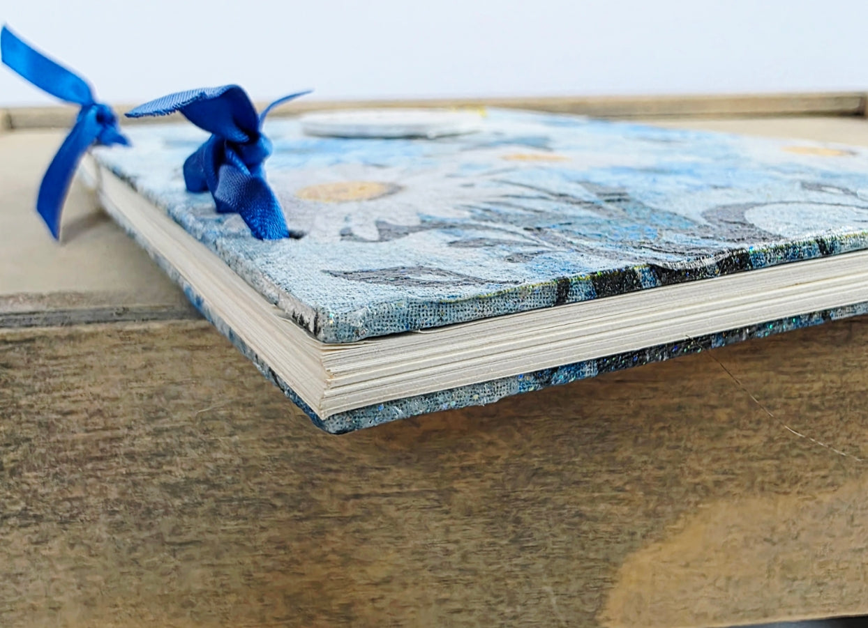 Book with a blue ribbon on a wooden surface