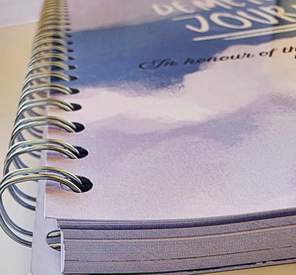 Close-up of a spiral-bound notebook with a scenic cover