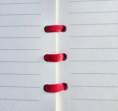 lined paper bound with red ribbon