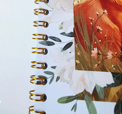 gold Spiral-bound notebook with floral design on a white background