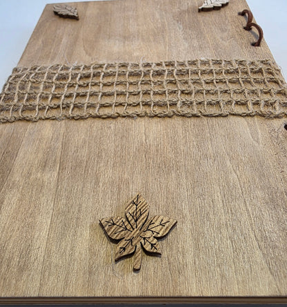 Wooden journal back cover with a wooden leaf design and burlap mesh across the middle