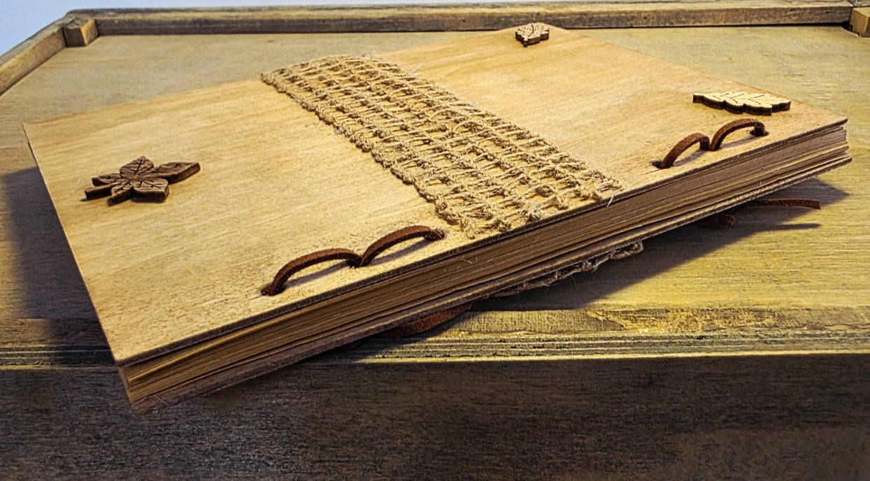 Wooden journal with decorative woodland elements on a wooden surface