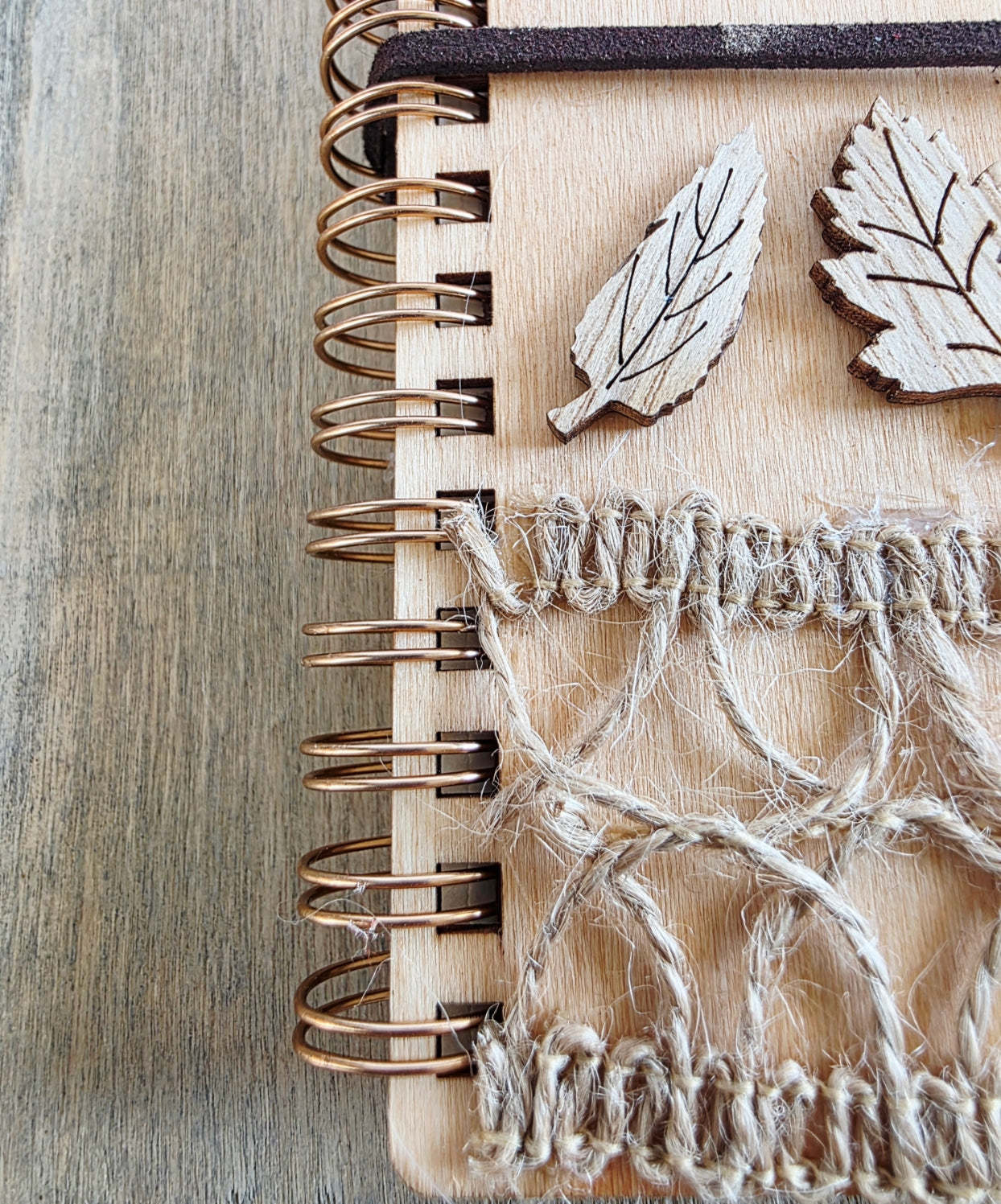 Wooden journal with decorative woodland elements and burlap design top. Dark brown faux suede tie. Round journal sign on the front. Spiral bound