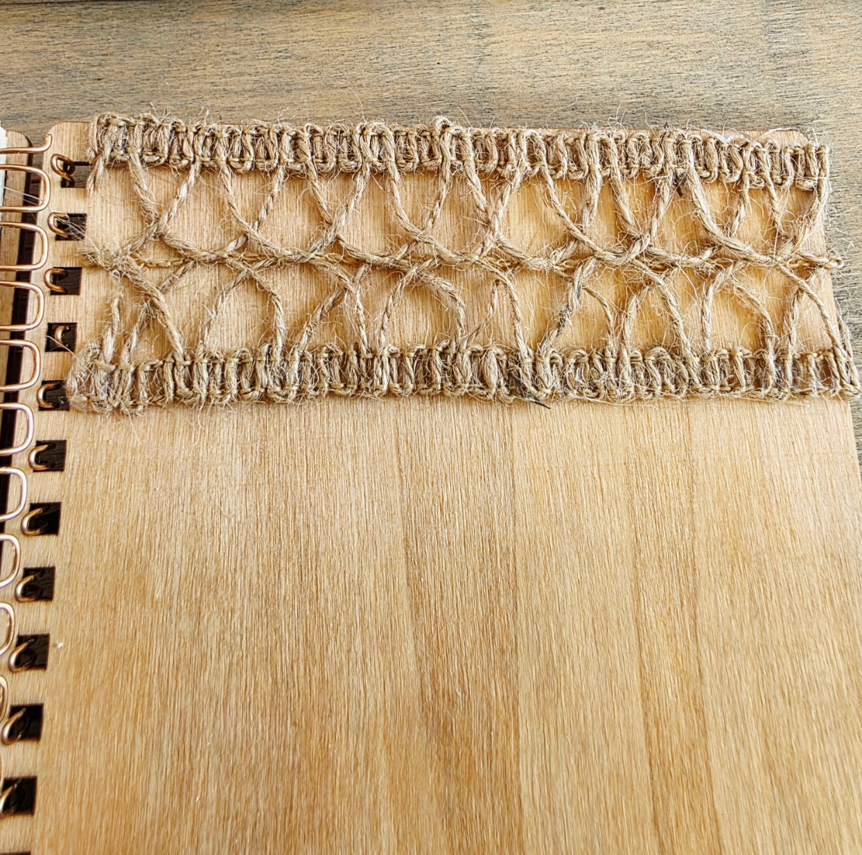 Close-up of a burlap texture on a wooden spiral bound notebook